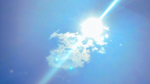 Foto do céu, fundo azul e sol com núvens ao meio.