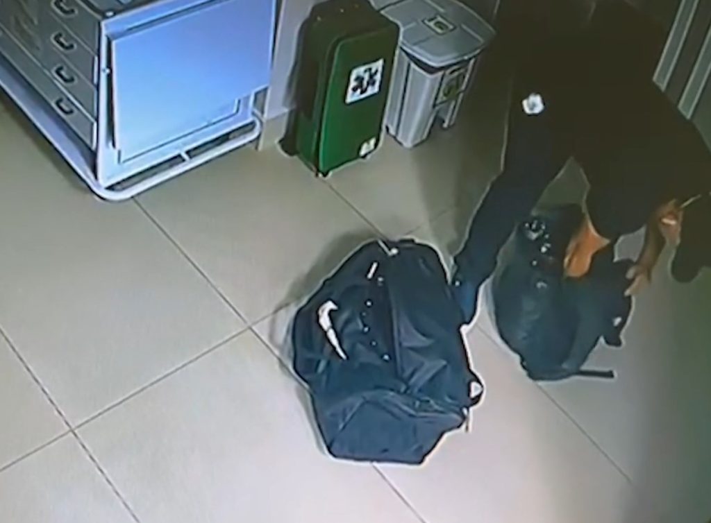Homem, vestido de camisa preta, colocando equipamentos hospitalares na mochila