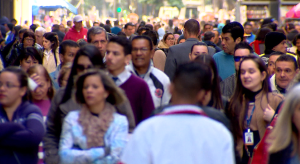 Pessoas andando com blusa de frio na rua