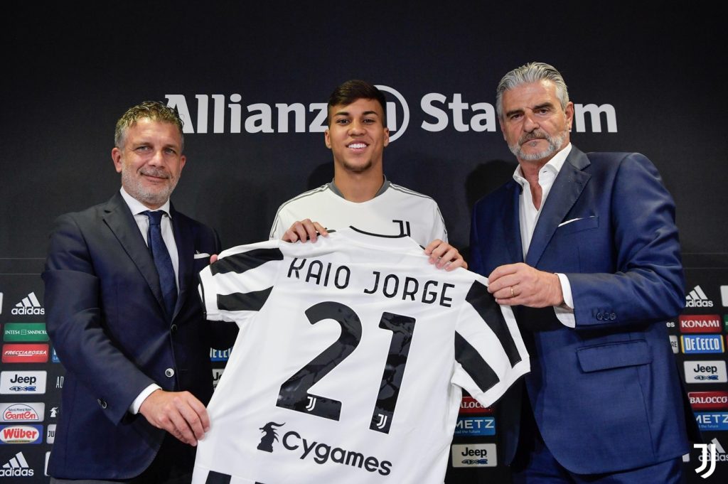 Kaio Jorge sendo apresentado como novo reforço da Juventus e segurando a camisa do clube