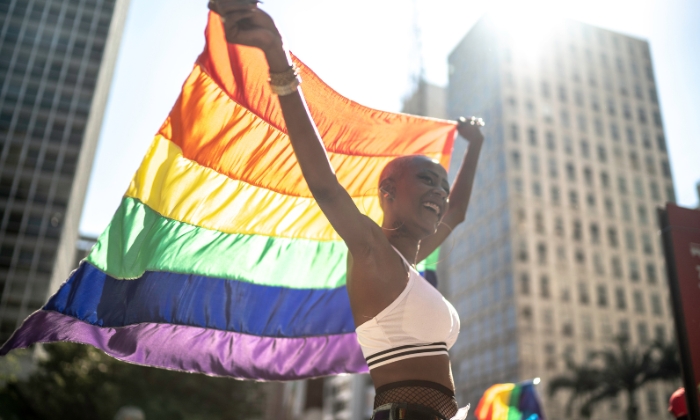 mulher negra segurando a bandeira de orgulho.