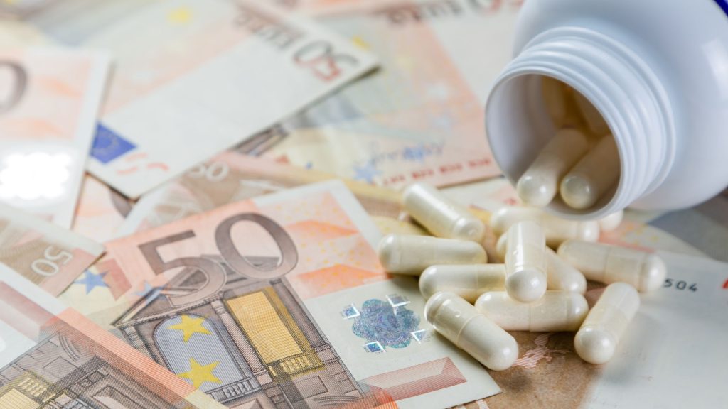 Medicamento em formato de comprimido e notas de dinheiro embaixo