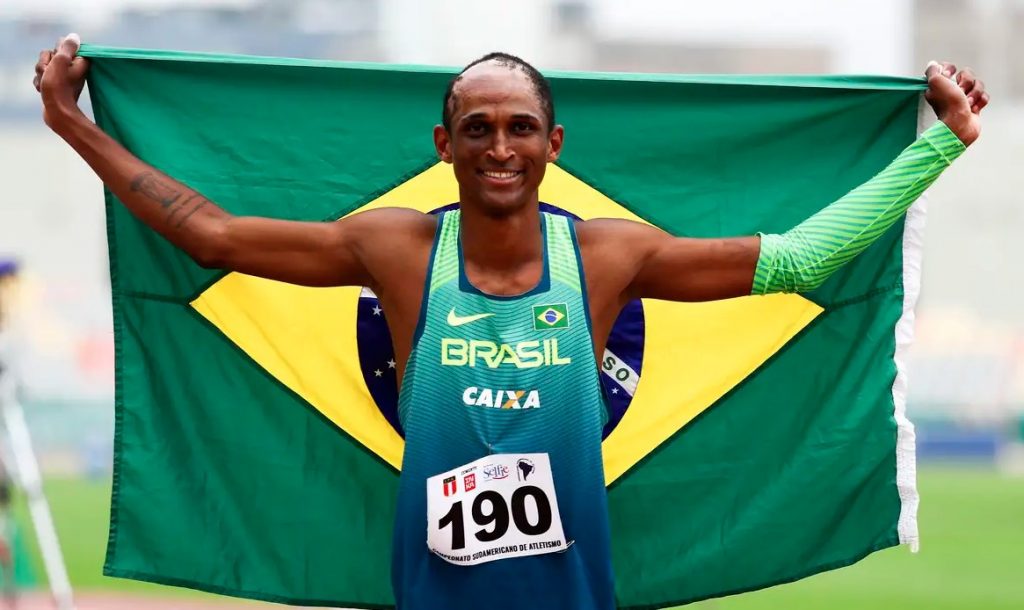 Alison dos Santos com a bandeira do Brasil