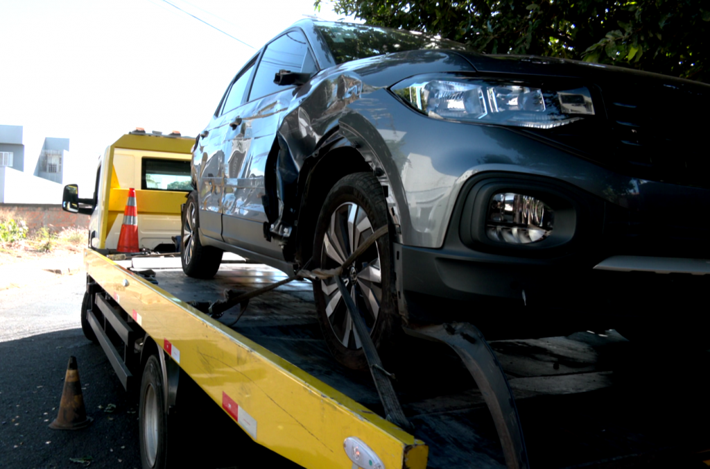 Carro danificado sendo guinchado da rua após acidente