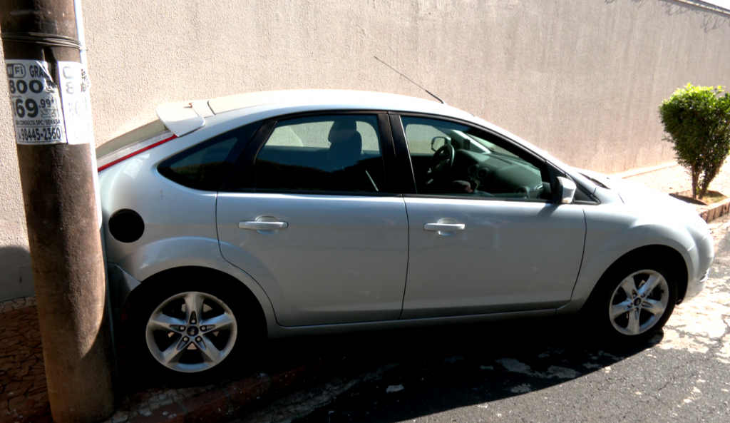 Carro parado com a traseira no poste de iluminação pública