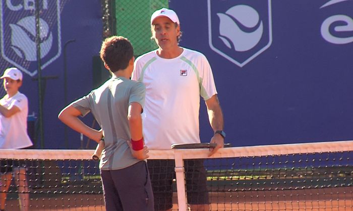 Fernando Meligeni conversando com jovem tenista