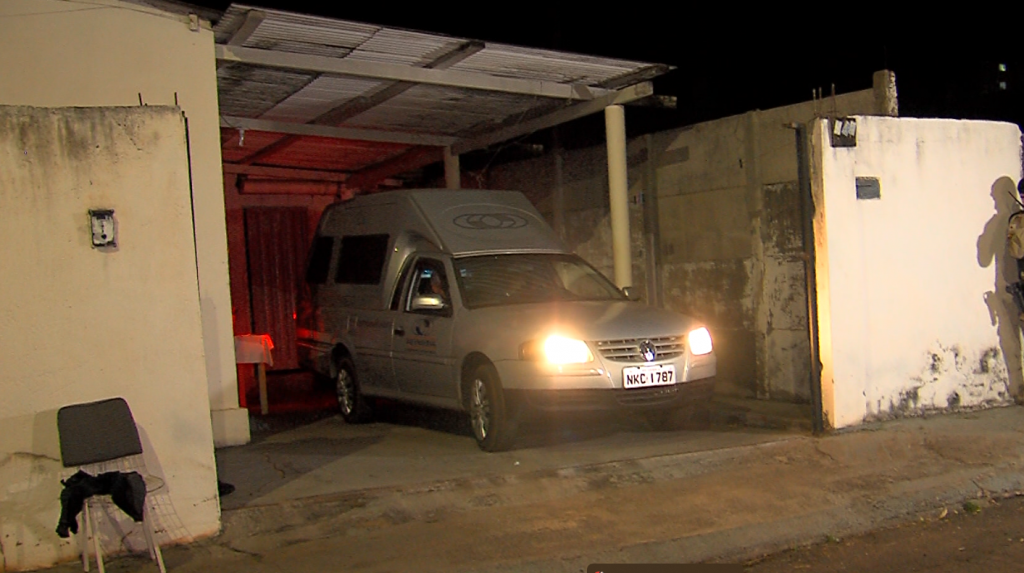 Carro da funerária saindo da casa onde os corpos do pai e filho foram encontrados