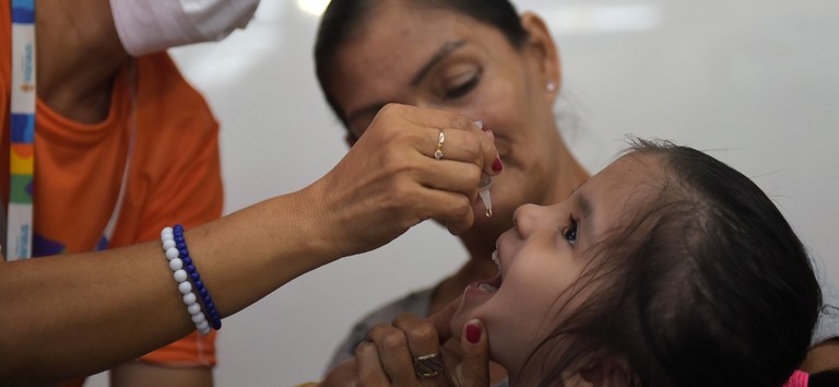 Criança tomando a gotinha da vacina contra a poliomielite