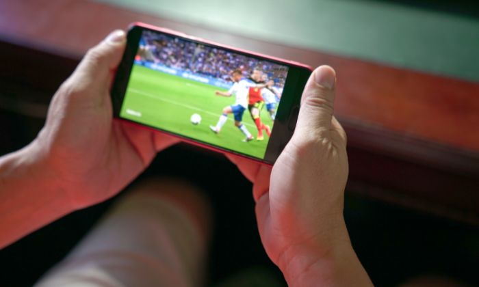 Homem assistindo jogo de futebol para prognóstico esportivo