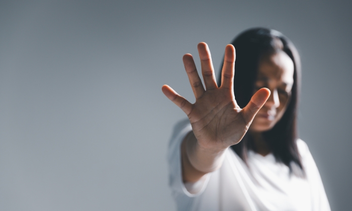 Mulher fazendo sinal de pare contra a violência