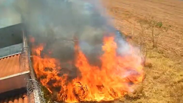 Incêndio em mata atingindo muro de condomínio