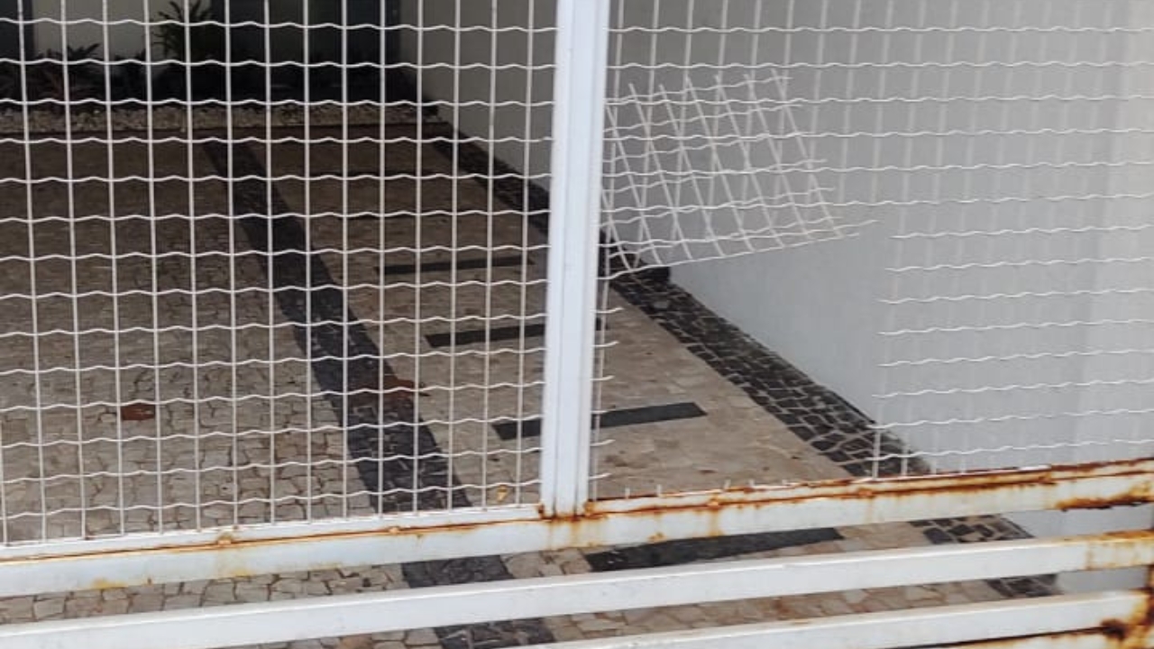 Buraco no portão do salão de beleza feito pelos bandidos