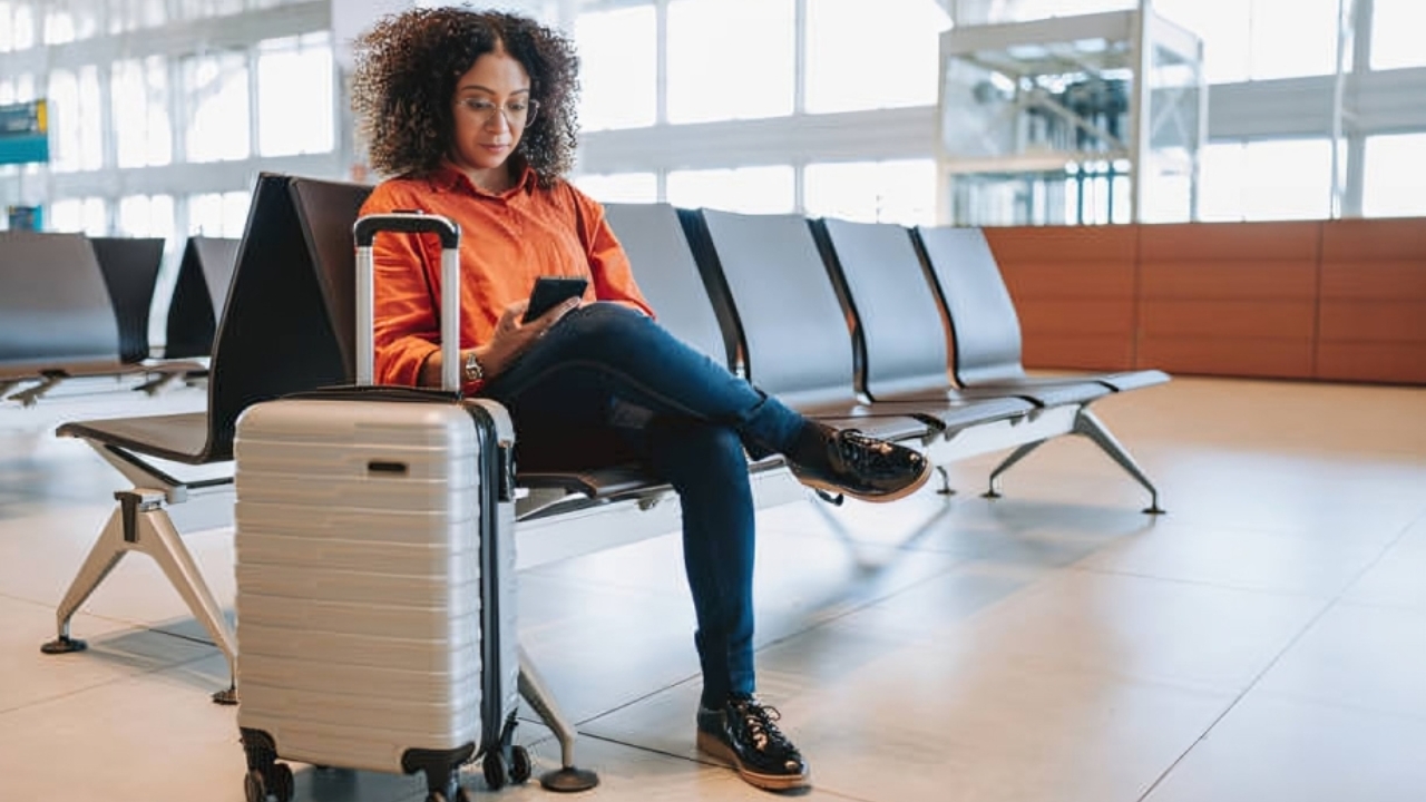 Mulher fazendo um pix enquanto aguarda o embarque no aeroporto