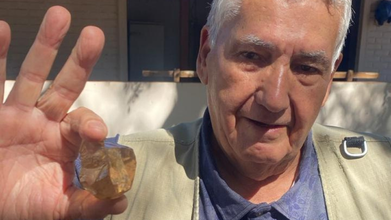 Homem segurando um diamante gigante