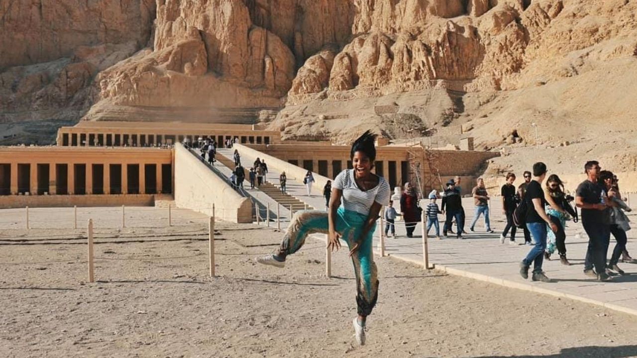 juliana-martins-em-viagem Julia, brasileira que caiu em vulcão na Indonésia, em uma foto de uma viagem no Egito. Pessoas ao fundo em um ambiente árido