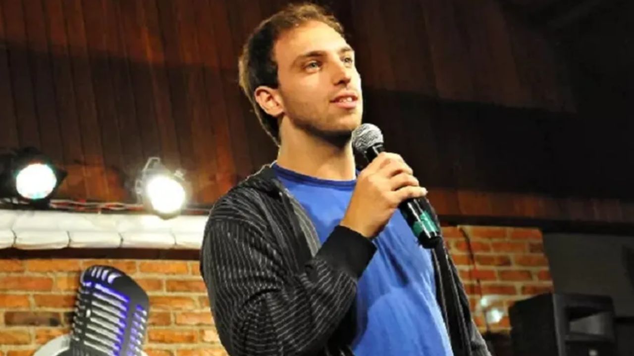 Comediante Leo Lins com microfone na mão, enquanto se apresenta em show de comédia