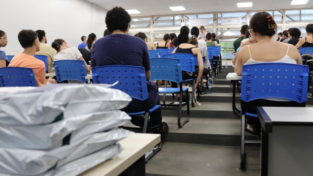 Alunos sentado em cadeiras dentro de sala de aula para prestar o vestibular da UFU na primeira etapa