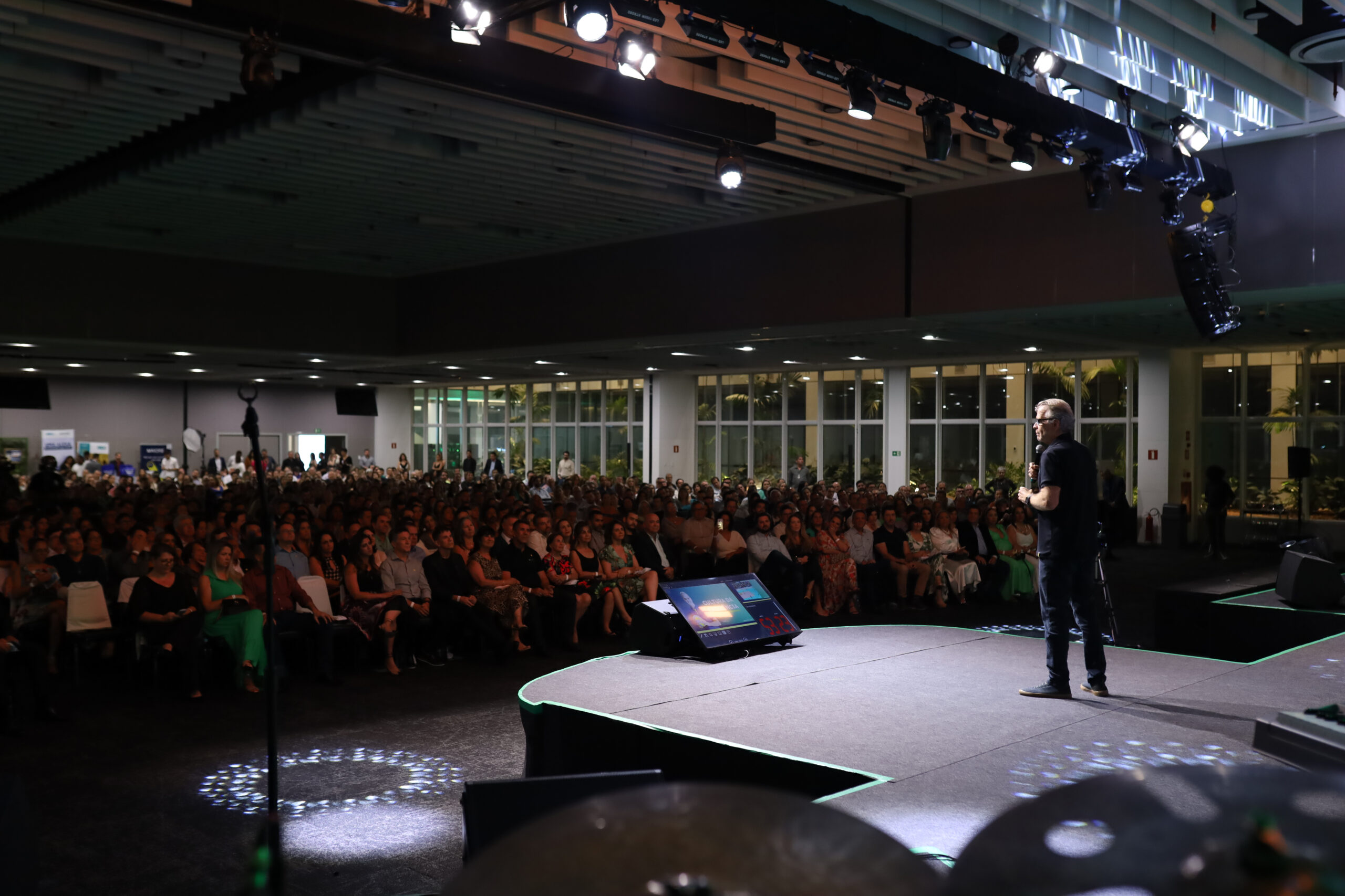 Palco de palestra da Collab Inovação com várias pessoas assistindo