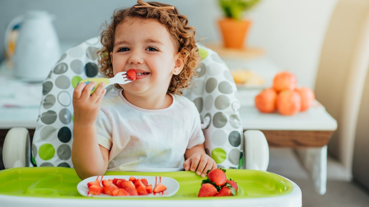 Criança se alimentando com frutas durante as férias escolares