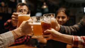 Pessoas brindando com copos de cerveja