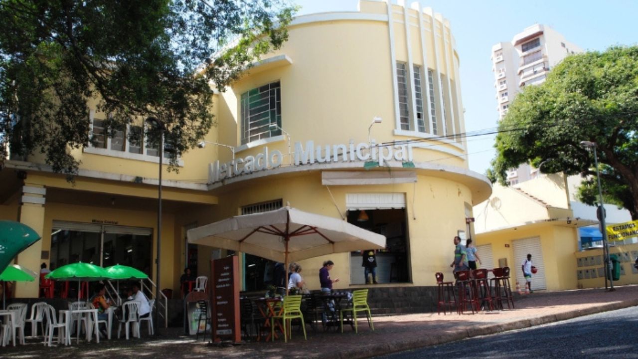 guia-completo-do-feriado-de-nossa-senhora-da-abadia Imagem do mercado municipal nas cores amarelo e branco, com mesas na calçada