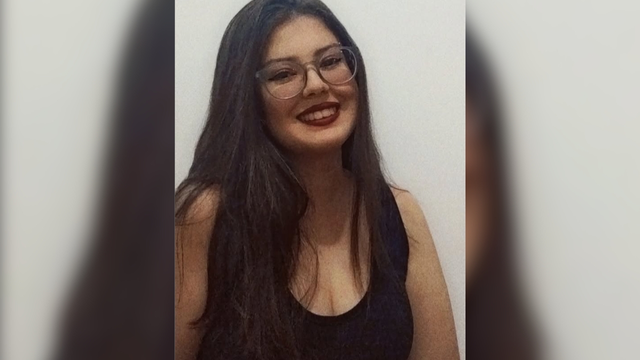 Vítima de explosão no Shopping Park, Danielle Silvestre. Na foto, usa óculos de grau, cabelo preto solto, batom vermelho e blusa preta