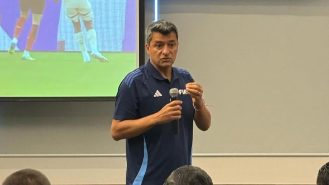 sandro meira ricci com microfone na mão dando palestra na fifa