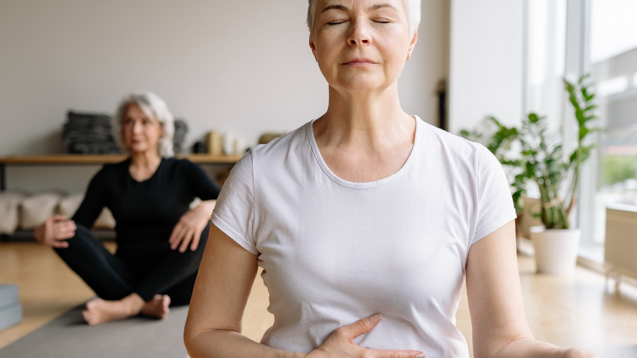Mulher fazendo Ioga para ilustrar os benefícios de exercícios e Como se preparar para a menopausa Mulher fazendo Ioga para ilustrar os benefícios de exercícios e Como se preparar para a menopausa